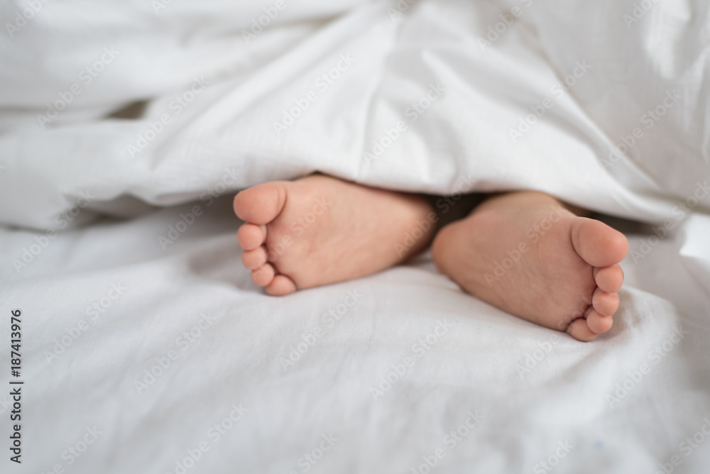 toddler feet in white bed,sheet and pillow - asian toddler sleeping toddler feet in white bed,sheet and pillow - asian toddler sleeping