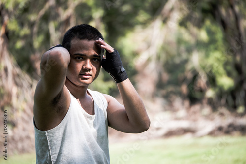 A Boxer practices his boxing step in a park.