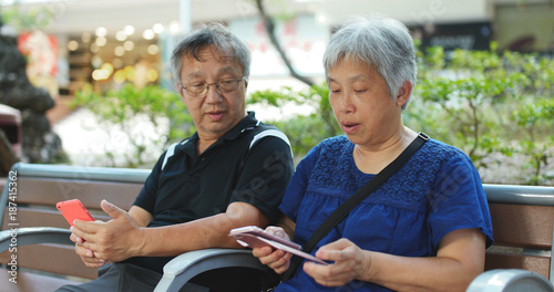 Asian senior couple use of cellphone together