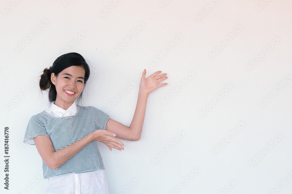Young cute asian businesswoman pointing to the blank wall with copy and text space - presentation skills concept Young cute asian businesswoman pointing to the blank wall with copy and text space - presentation skills concept