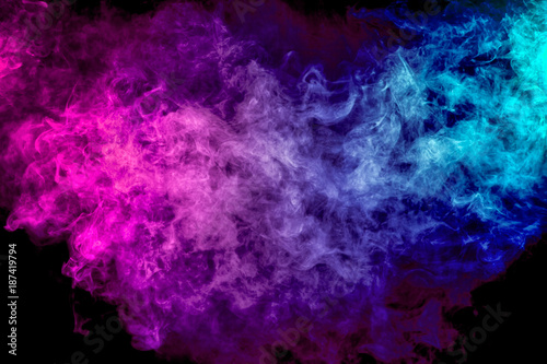 Fotografia Thick colorful smoke of purple, blue, white on a black isolated background