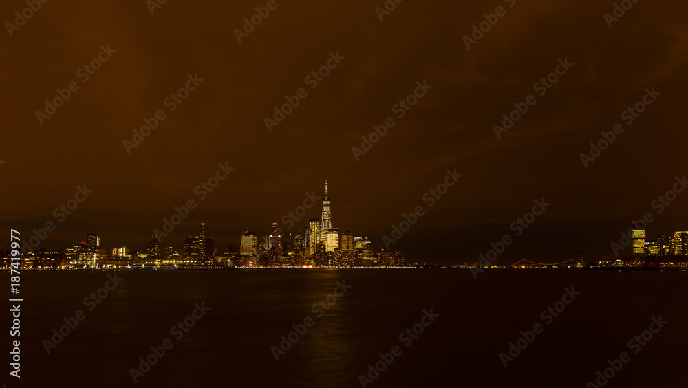 Panorama of Manhattan across Hudson River at night, New York City. Brightly lit New York skyscrapers during winter holiday season.