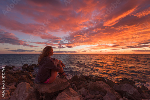 Woman admiring the seascape during sunrise photo