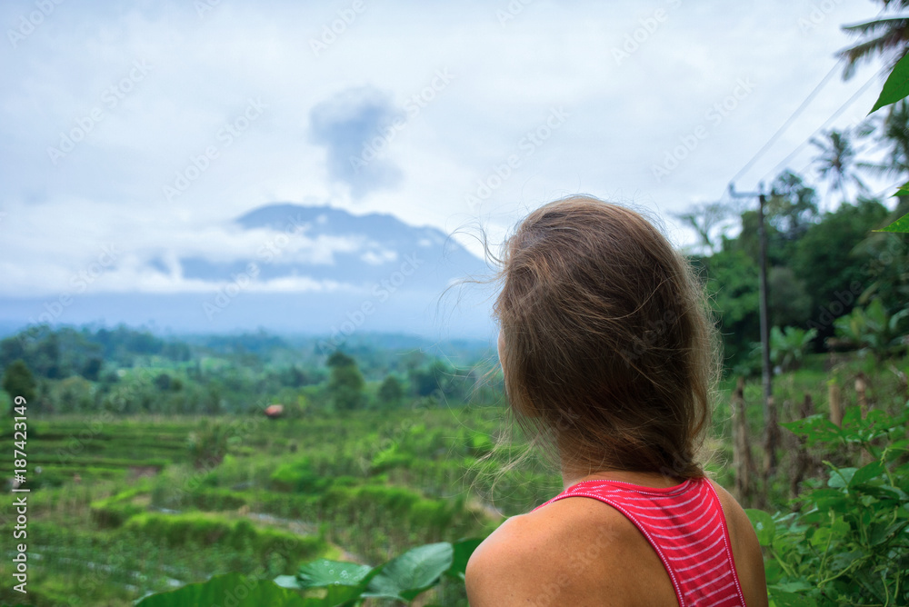 Woman is looking at Agung volcano eruption in Bali, Indonesia Woman is looking at Agung volcano eruption in Bali, Indonesia
