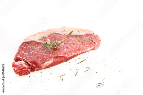Fresh raw beef steak with pepper and rosemary isolated in white background