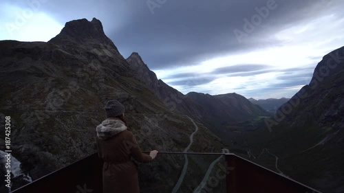 young woman enjoys the view of Trollstigen, Norway photo