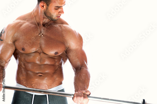 Closeup of handsome male fitness model posing shirtless showing perfect abdominal muscles over white background. .