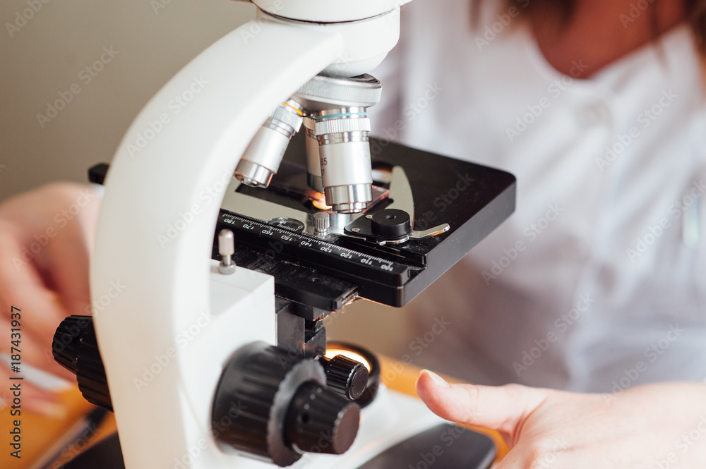 Scientist using a microscope in a laboratory Scientist using a microscope in a laboratory