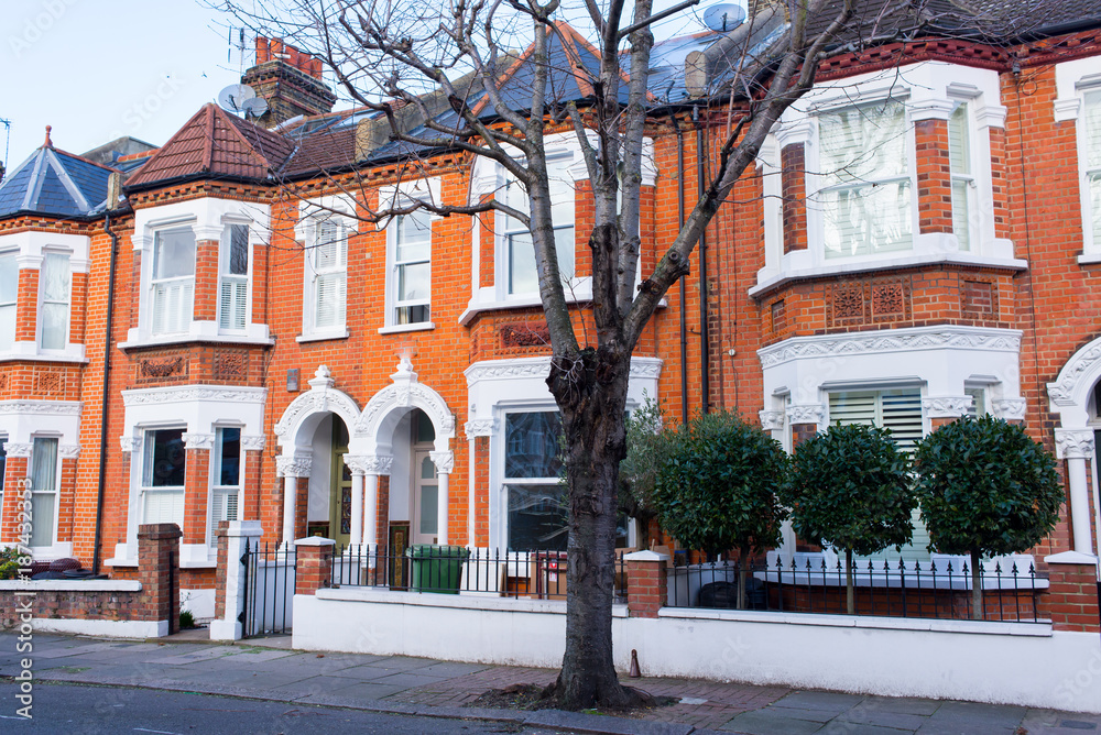 Obraz premium Row of restored Victorian house in red bricks and white finishing on a local street in Clapham, South London, UK
