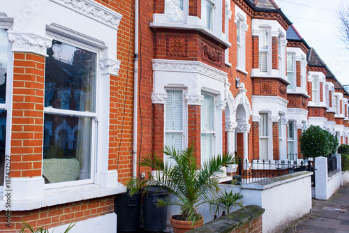 Row of restored Victorian house in red bricks and white finishing on a local street in Clapham, South London, UK photo