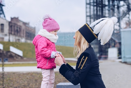 Woman in black coal miner gala uniform with her child.
