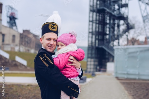 Black coal foreman miner in gala uniform with his child.
