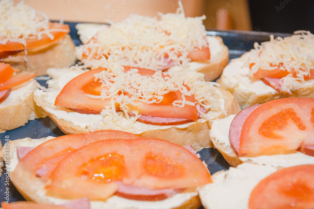 Tomato and cheese sandwich. The bread slice with tomato and cheese lies on a leaf. Tomato and cheese sandwich. The bread slice with tomato and cheese lies on a leaf.