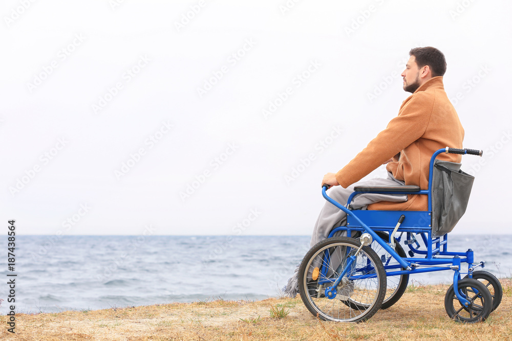 Fototapeta premium Man in wheelchair on sea shore