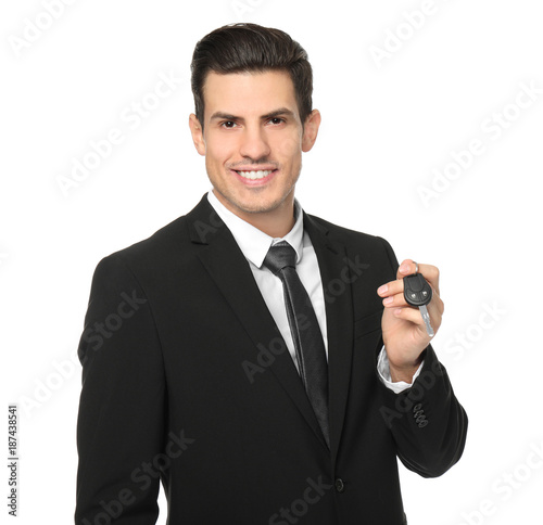 Salesman in formal suit holding car key on white background
