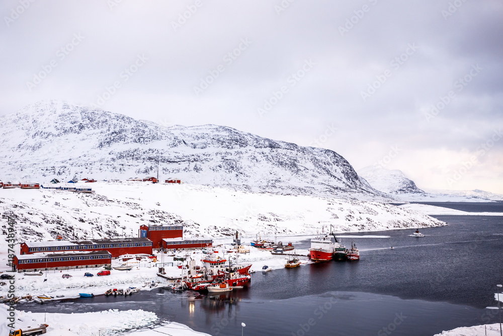 Fishing boats and harbor buildings with mountains in the background, port of Nuuk, Greenland Fishing boats and harbor buildings with mountains in the background, port of Nuuk, Greenland