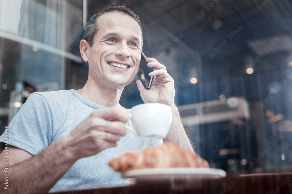 Nice atmosphere. Delighted brunette expressing positivity while speaking with his friend and having break