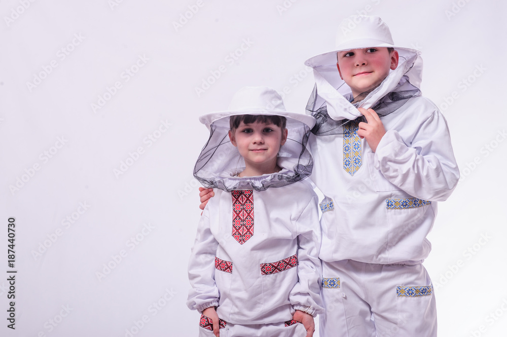 Kids in beekeeper's suits posing in studio white background. Kids in beekeeper's suits posing in studio white background.