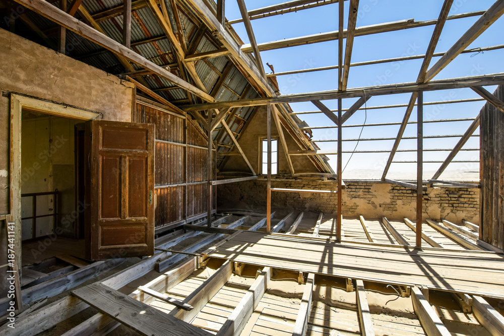 Inside view of one of the abandoned houses in the ghost town of Kolmanskop near Lüderitz in Namibia, Africa. After the diamond rush ended, the houses are slowly getting swallowed by sand and dunes.