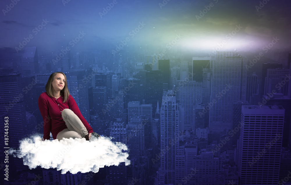 Woman sitting on cloud above the city Woman sitting on cloud above the city
