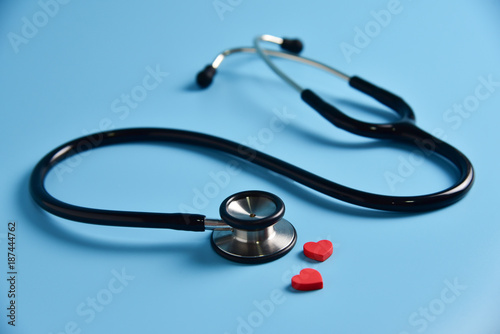 Two Red hearts with stethoscope on blue background.