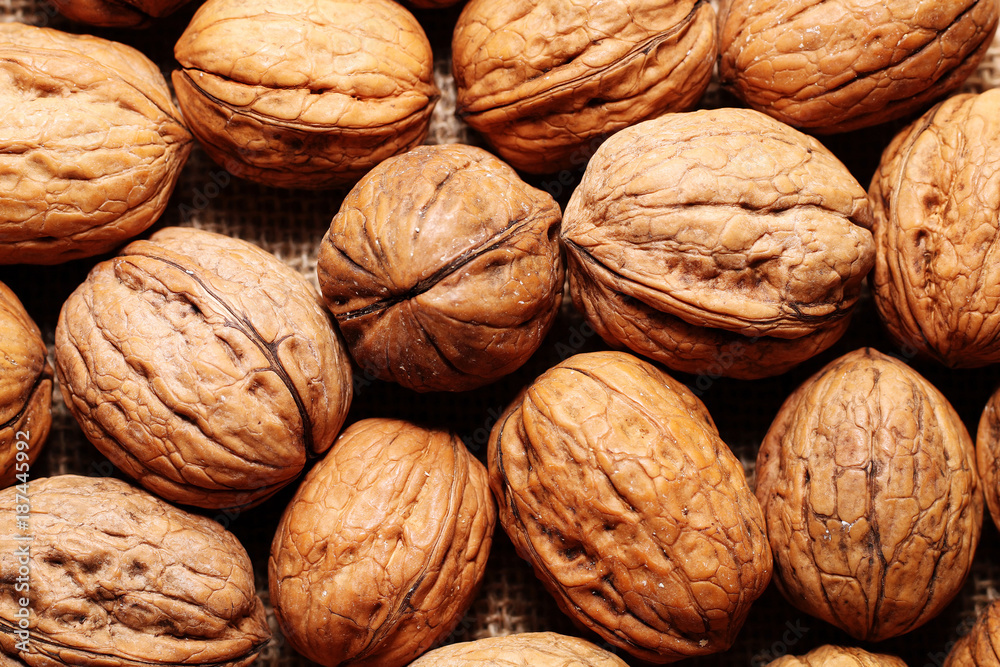 Spilled walnuts on the background of sack cloth Spilled walnuts on the background of sack cloth