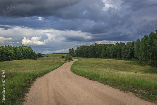 Dust road among meadows in Masurian Lakeland region of Poland