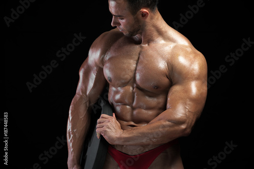 Portrait of male bodybuilder with relief muscles. Muscular middle aged fitness model posing with weight in hands. High resolution