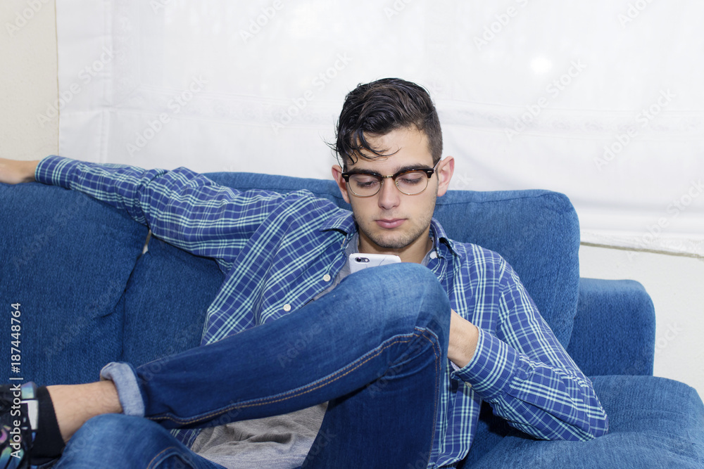 young casual in the home sofa with mobile phone young casual in the home sofa with mobile phone