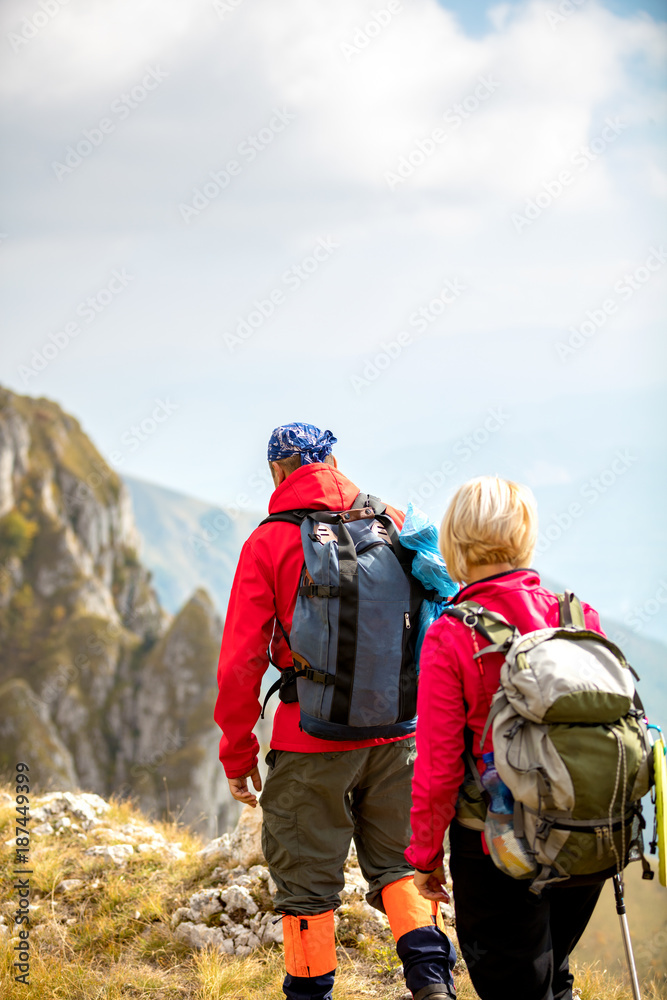 adventure, travel, tourism, hike and people concept - smiling couple walking with backpacks outdoors