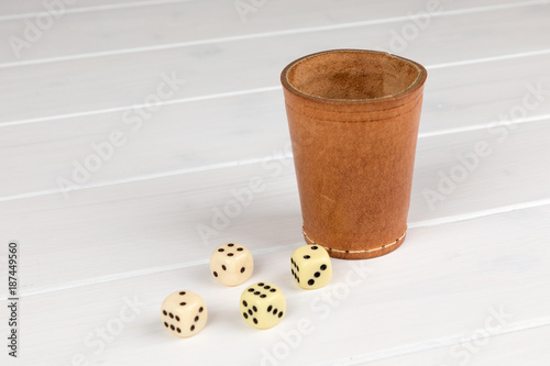 dice cup with cube wooden background