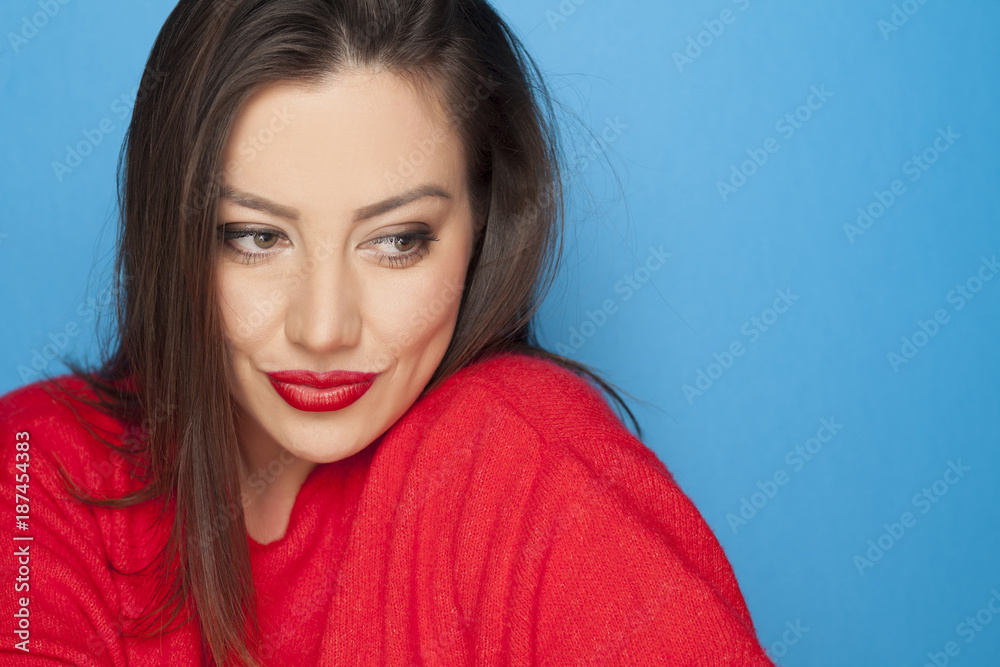 Fototapeta premium beautiful woman in a red blouse on a blue background