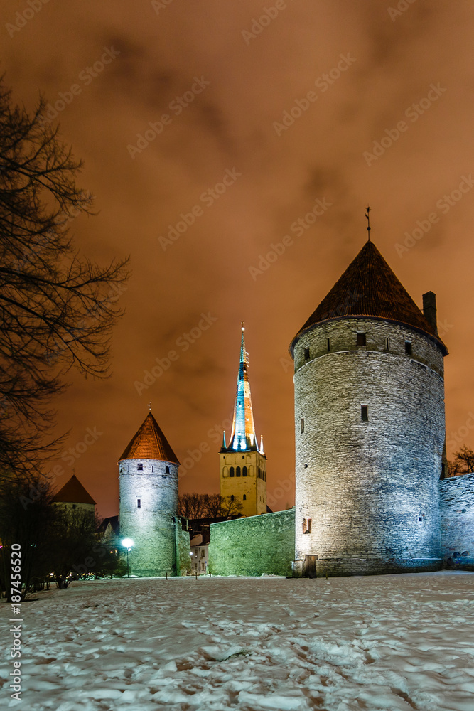 Toompea castle walls and towers highlighted by street lamps in the snow night, Tallinn, Estonia