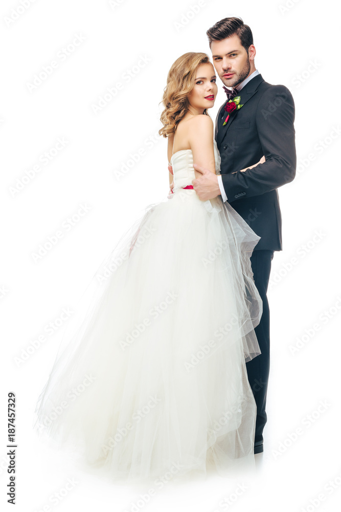 side view of wedding couple hugging each other and looking at camera isolated on white side view of wedding couple hugging each other and looking at camera isolated on white