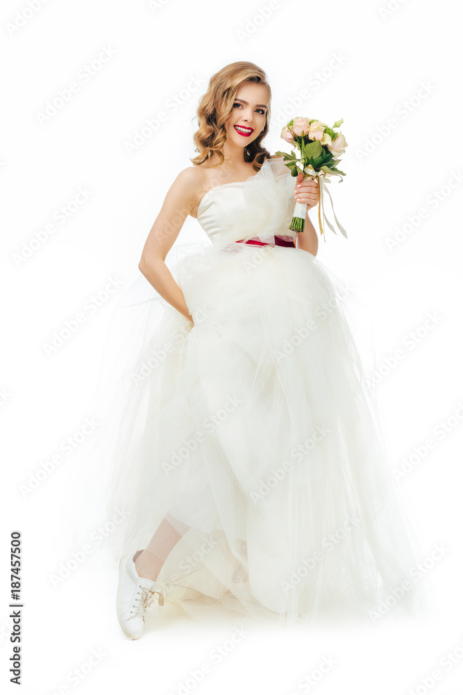 smiling bride in beautiful wedding dress with flowers in hand isolated on white