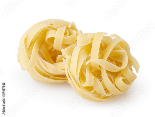 Uncooked nests of tagliatelle pasta isolated on white background with clipping path