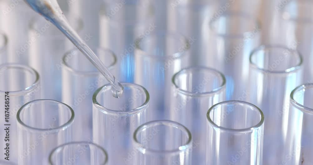 Pipette drips blue chemicals into a test tube Pipette drips blue chemicals into a test tube