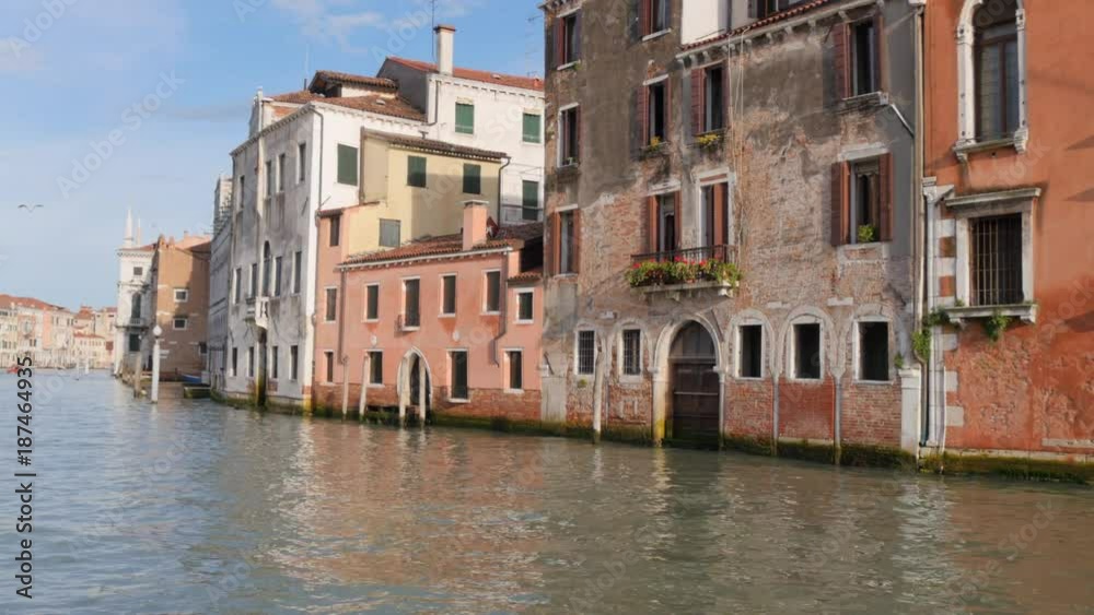 Moving through the Grand Canal in Venice in Italy by water bus. Showing historic buildings at waterfront. Moving through the Grand Canal in Venice in Italy by water bus. Showing historic buildings at waterfront.