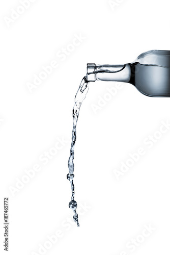 Photo water pouring from glass bottle isolated on white