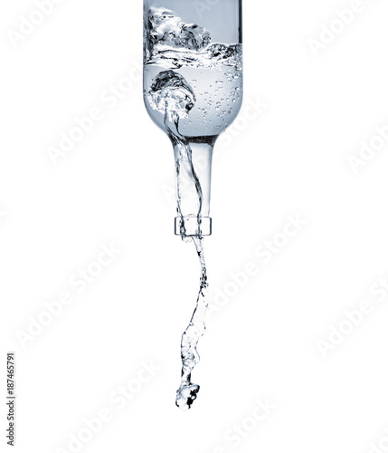 Canvas Print motion shot of water pouring from glass bottle isolated on white