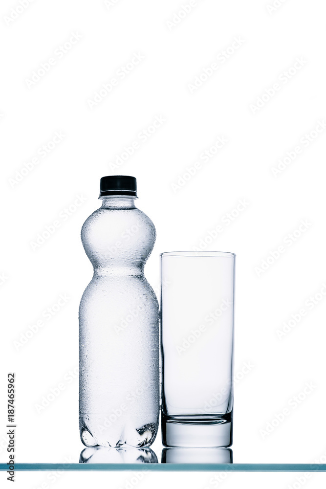 full plastic bottle of water and empty glass isolated on white full plastic bottle of water and empty glass isolated on white