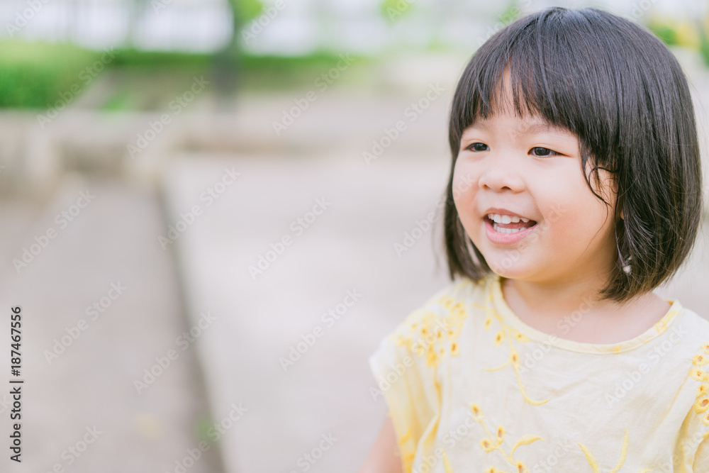 Little asian girl smiling with perfect smile and white teeth in a park and looking at camera.Little girl child showing front teeth with big smile.Joyful portrait of asian elementary school student. Little asian girl smiling with perfect smile and white teeth in a park and looking at camera.Little girl child showing front teeth with big smile.Joyful portrait of asian elementary school student.