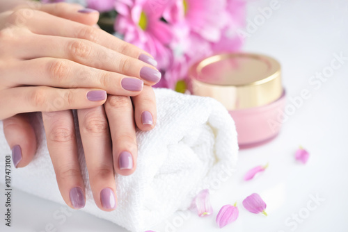 Women s hands with pink manicure are on a towel