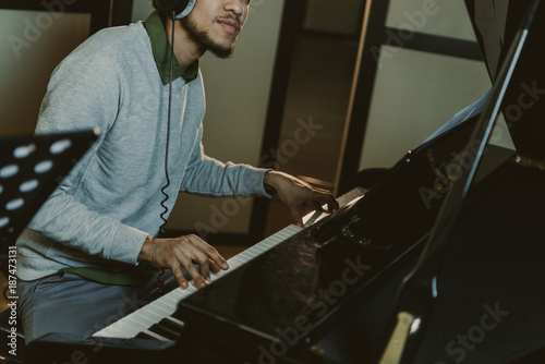 cropped shot of african american man playing piano at studio