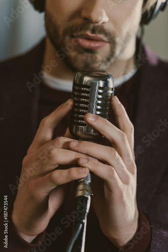 cropped shot of singer holding microphone and performing song