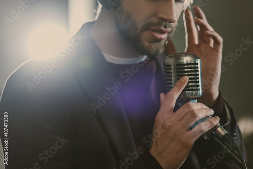 attractive young singer in headphones performing song at studio