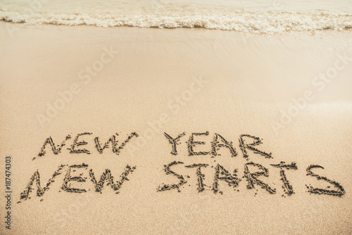 New Year New Starts text written on the sand