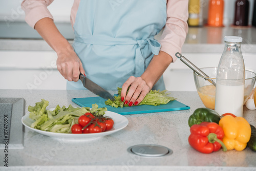 Fototapeta Naklejka Na Ścianę i Meble -  cropped image of woman cutting vegetables for salad