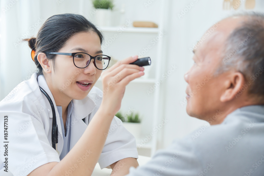 Female Doctor checking to senior man patient eyes. Female Doctor checking to senior man patient eyes.