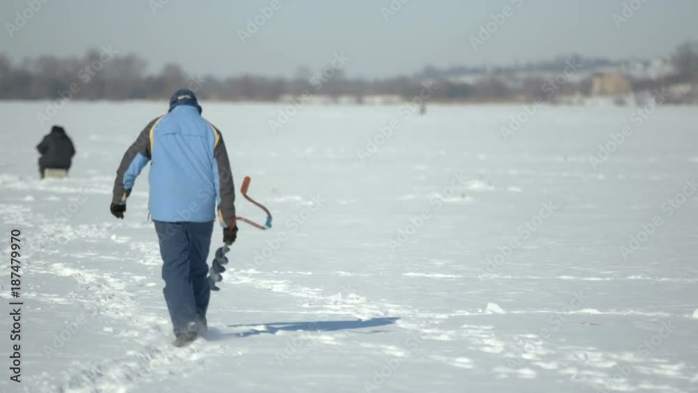 Fishermen on ice. winter fishing on a frozen lake near the city park Ternopil Ukraine Fishermen on ice. winter fishing on a frozen lake near the city park Ternopil Ukraine